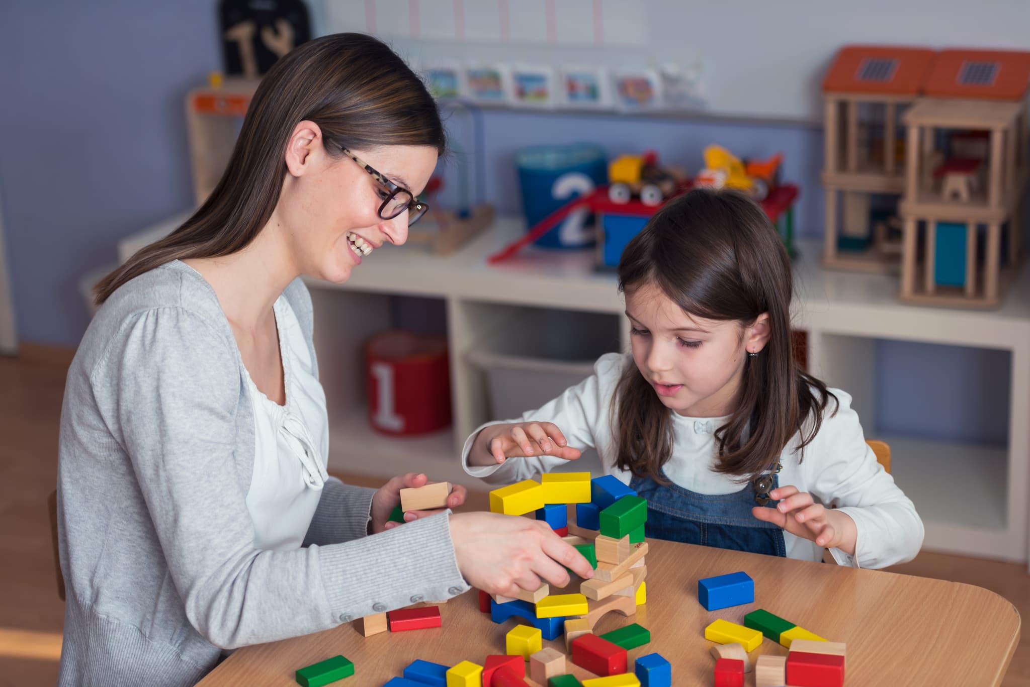 Therapist and child playing with building blocks